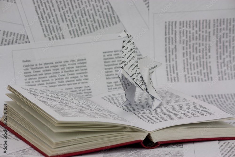 Obraz premium Origami dinosaur coming out of a book