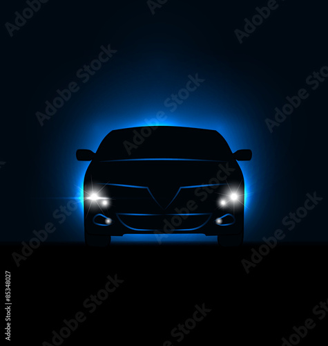 Silhouette of car with headlights in darkness