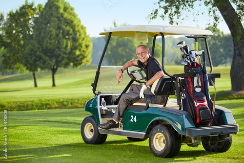 Mature man sitting in a golfcart photo
