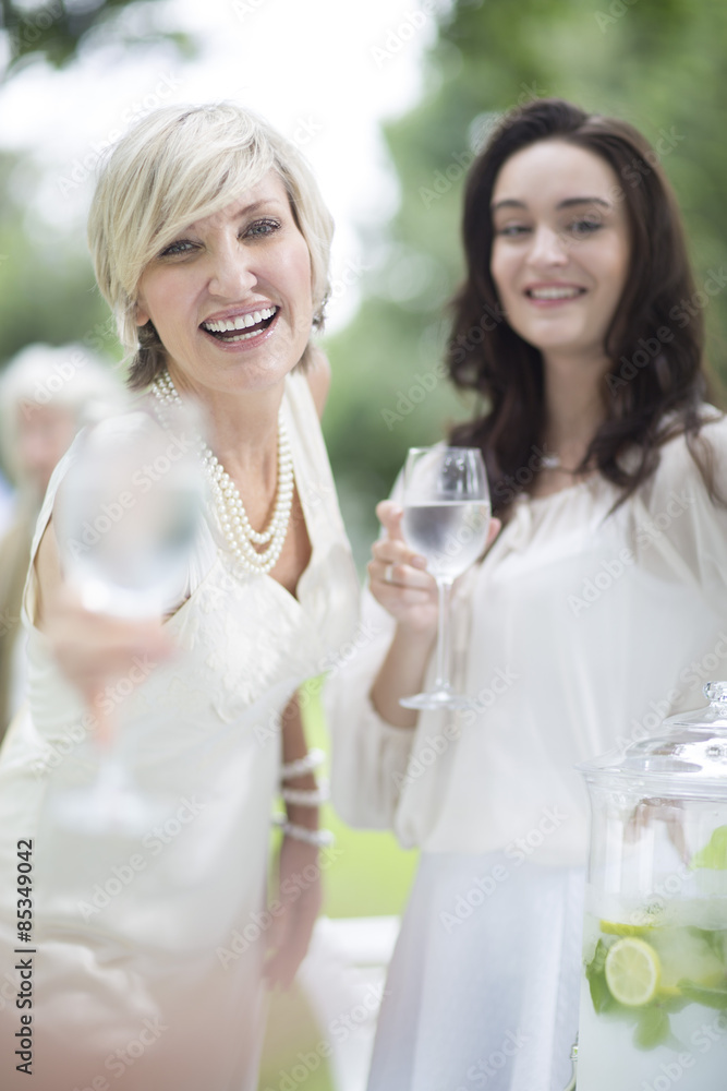 Two smiling women holding wine glasses outdoors Two smiling women holding wine glasses outdoors