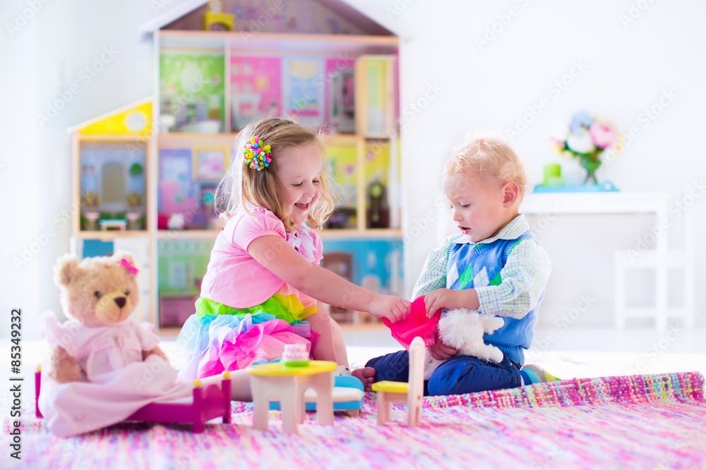 Fototapeta premium Kids playing with stuffed animals and doll house