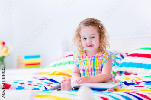 Little girl reading in bed