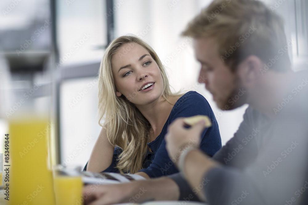 Young couple sitting at table having breakfast Young couple sitting at table having breakfast