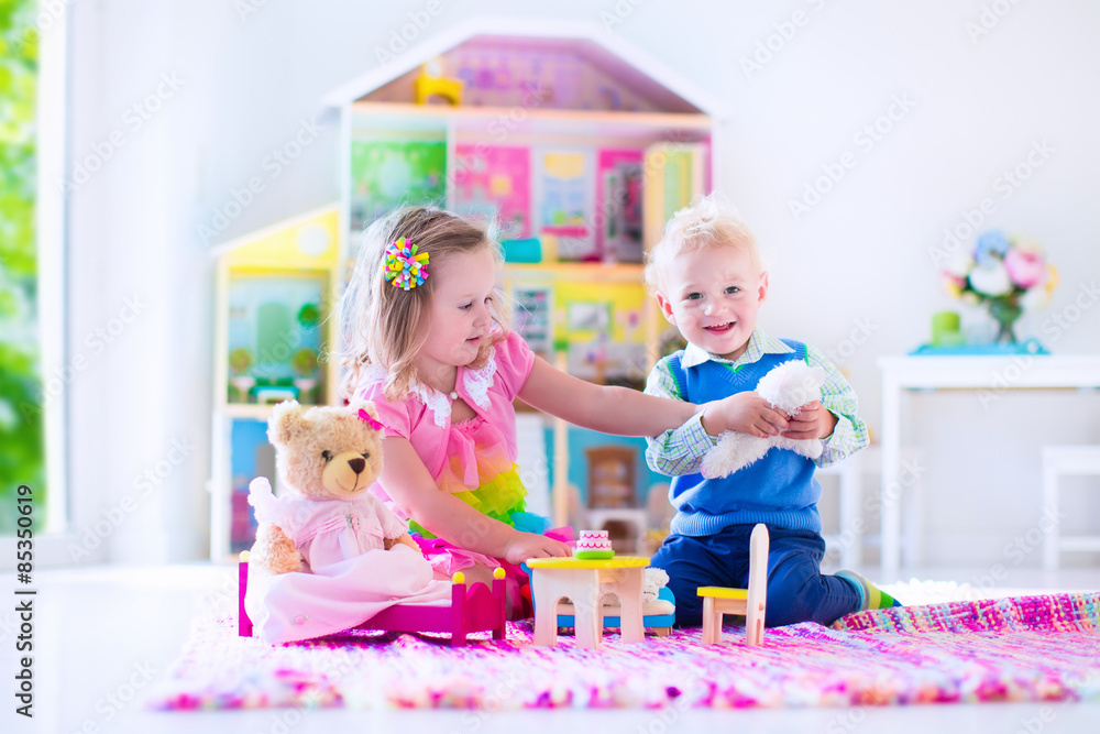Fototapeta premium Kids playing with stuffed animals and doll house