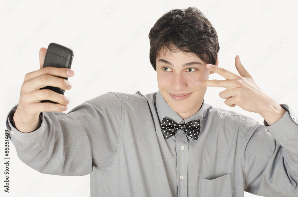 Naklejka premium Happy businessman taking a selfie photo with his smart phone. Conceited elegant man holding mobile phone signing victory. 