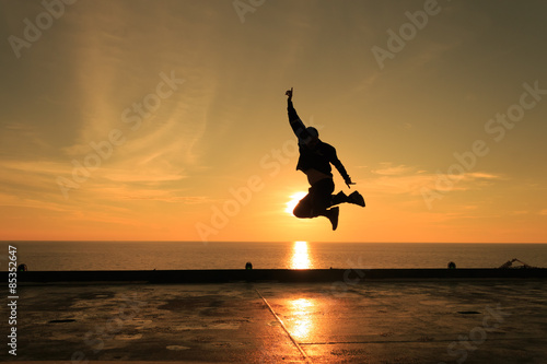Man jumping against beautiful sunset. Freedom and enjoyment 