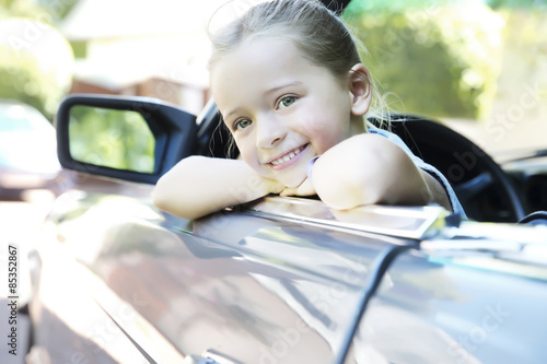 Blonde girl sitting in convertible photo