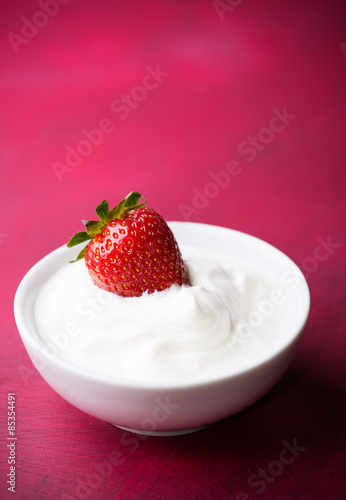 Strawberry in a bowl with cream