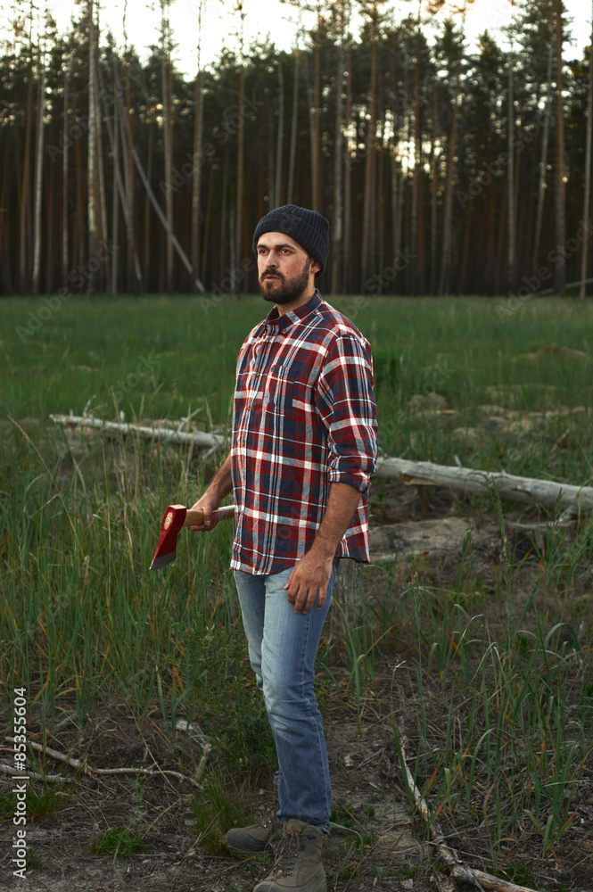 Fototapeta premium Portrait of bearded Lumberjack with Hat, Shirt and Ax