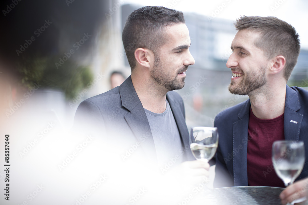 Gay couple drinking wine at a restaurant Gay couple drinking wine at a restaurant