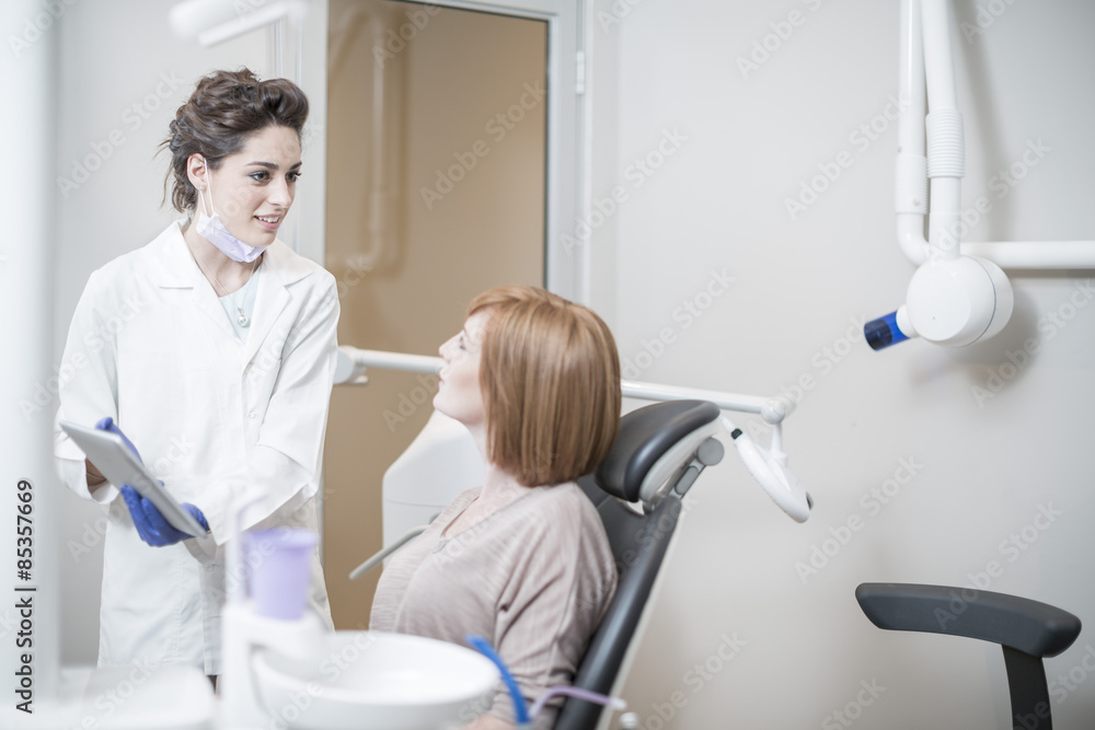 Dentist explaining a procedure and results with a patient Dentist explaining a procedure and results with a patient