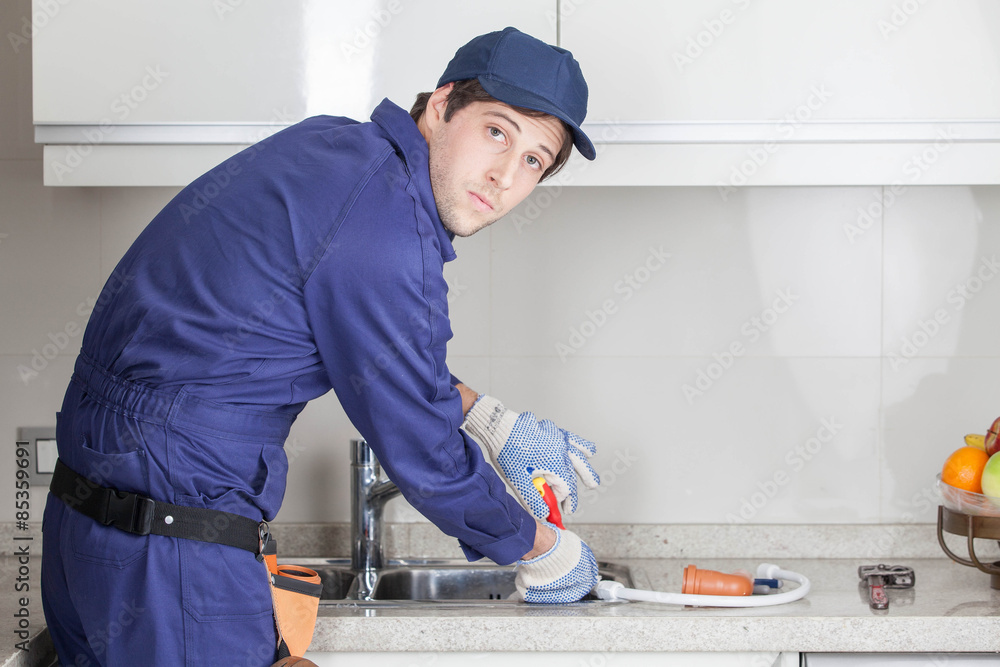 Serious plumber fixing the sink Serious plumber fixing the sink