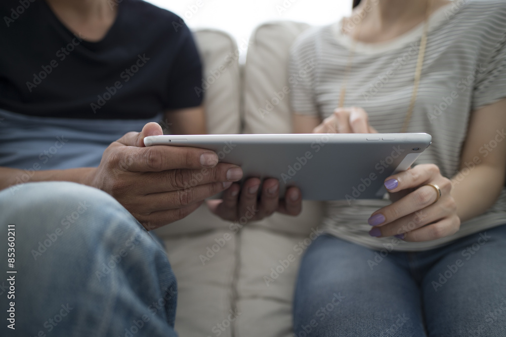 The couple are looking at a tablet together