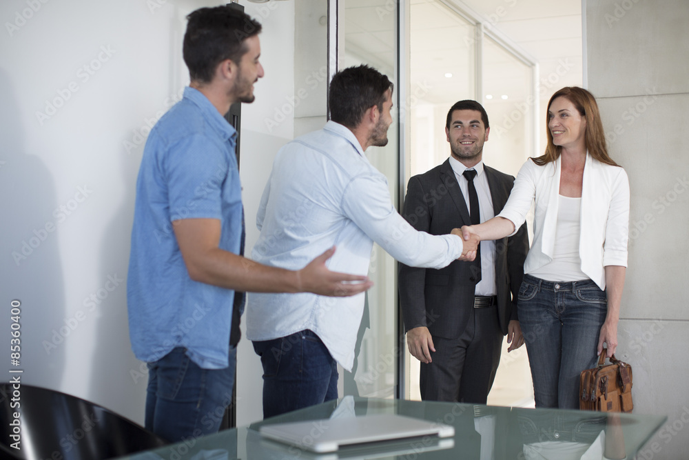 Twin males dressed casually in office meeting with clients Twin males dressed casually in office meeting with clients