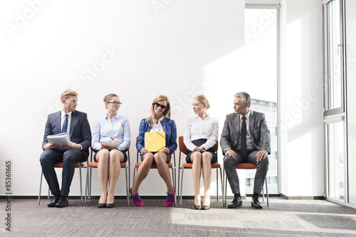 People sitting in a row, waiting for job interview
