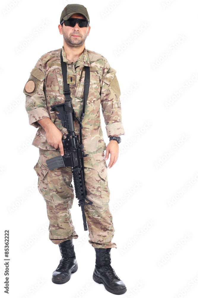 Full length portrait of young man in army clothes holding a weap