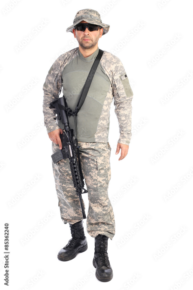 Full length portrait of young man in army clothes holding a weap Full length portrait of young man in army clothes holding a weap
