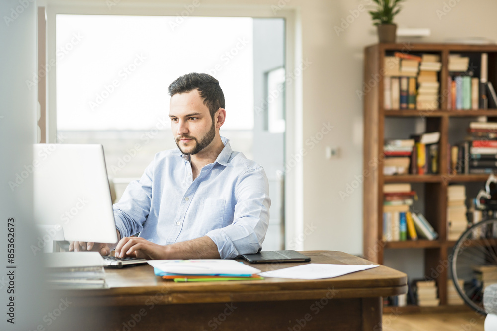 Young man working at computer at home Young man working at computer at home