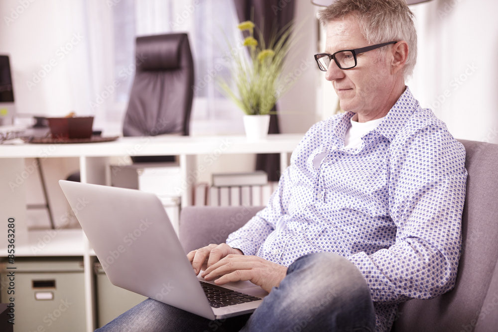 Businessman working with laptop at home office Businessman working with laptop at home office