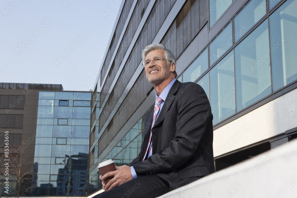 Smiling businessman with coffee to go Smiling businessman with coffee to go