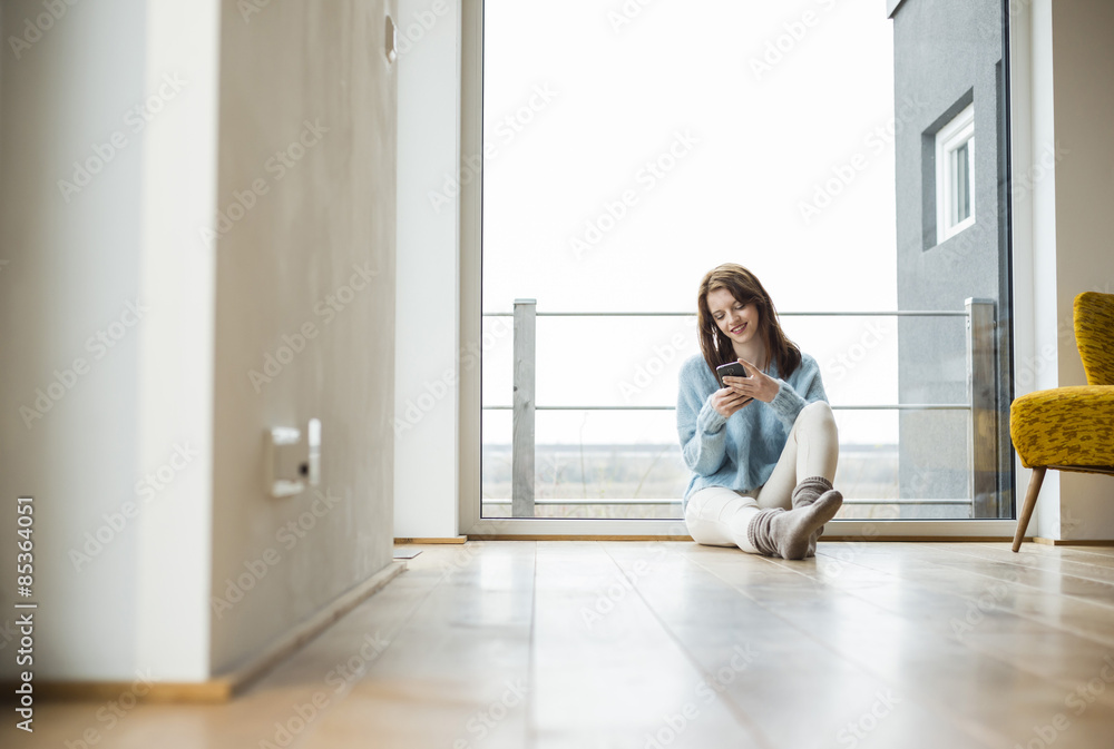 Young woman sitting on floor using digital tablet Young woman sitting on floor using digital tablet