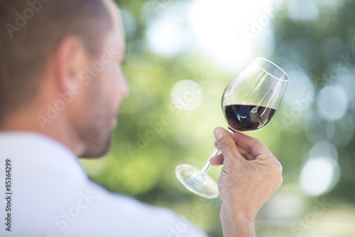 Man examining red wine on a wine tasting session photo