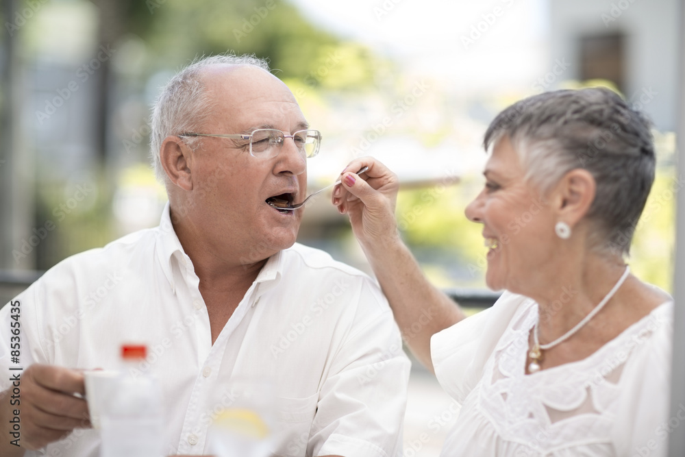 Wife feeding husband some cake Wife feeding husband some cake