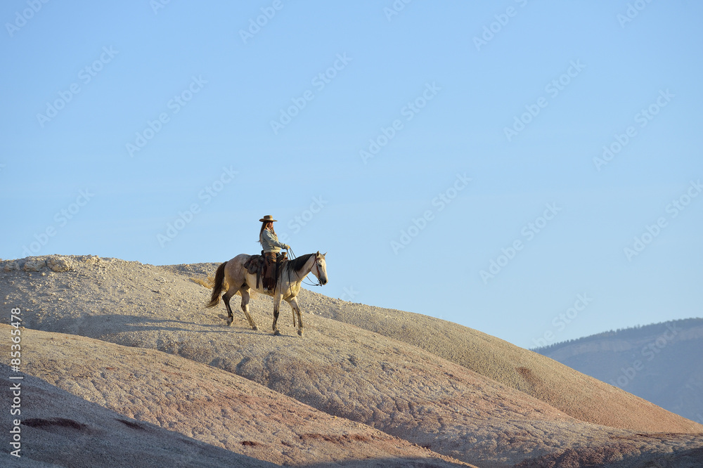 USA, Wyoming, cowgirl riding in badlands USA, Wyoming, cowgirl riding in badlands