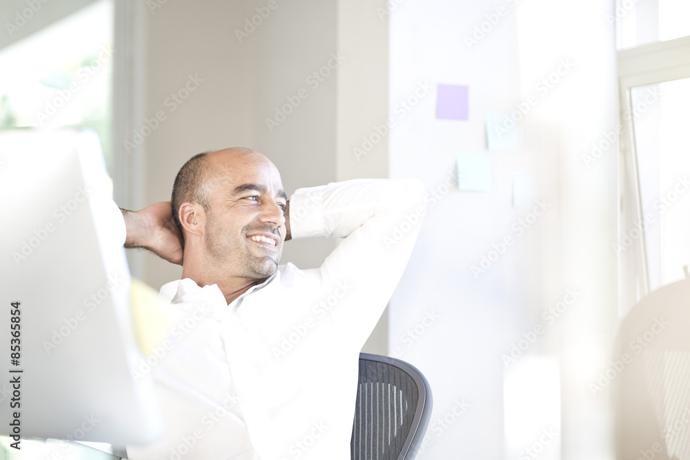 Portrait of businessman relaxing at desk in an office Portrait of businessman relaxing at desk in an office