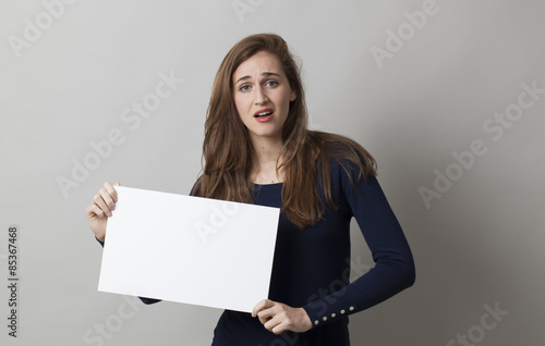 young disappointed woman searching for a better answer with white board in her hands