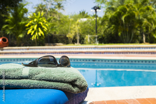 Swimmingpool, Sonnenliege, Handtuch mit Sonnenbrille photo