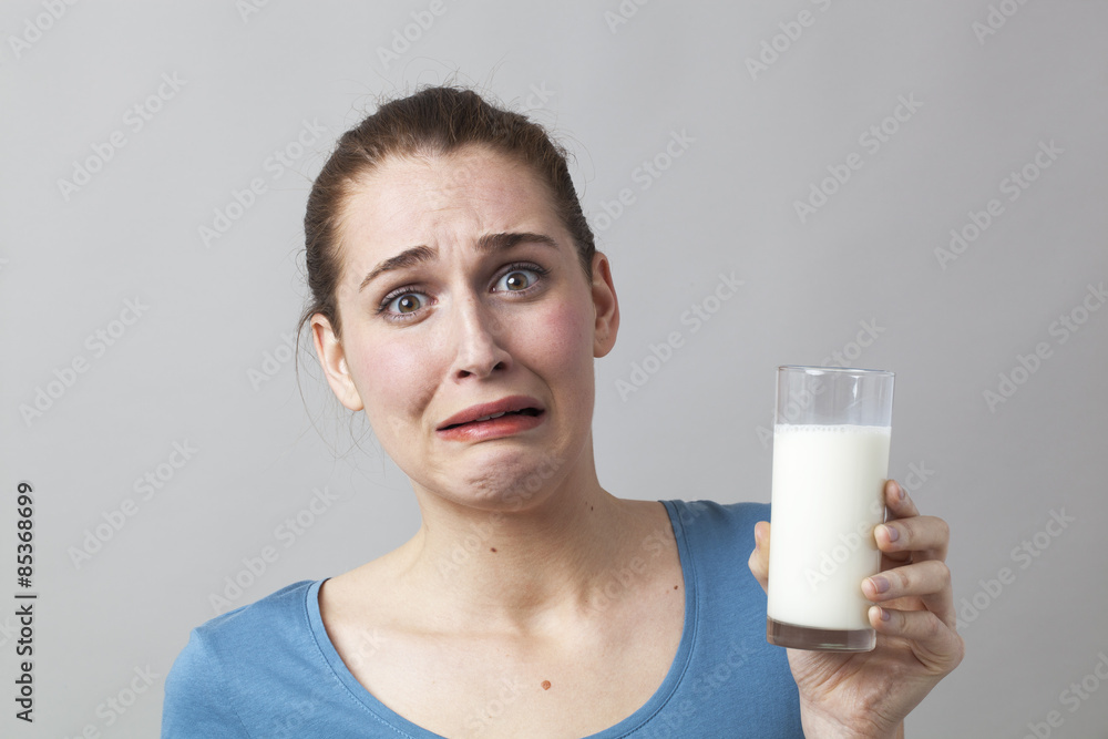 scared young woman panicking at the idea of drinking a glass of smelly milk or disgusting white beverage scared young woman panicking at the idea of drinking a glass of smelly milk or disgusting white beverage