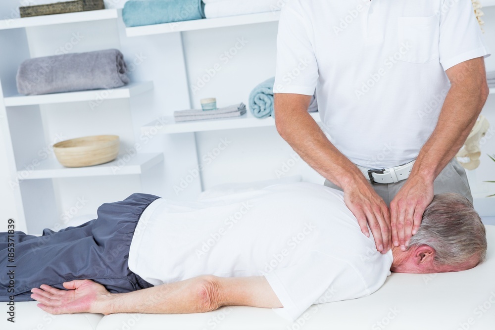 Physiotherapist doing neck massage to his patient Physiotherapist doing neck massage to his patient