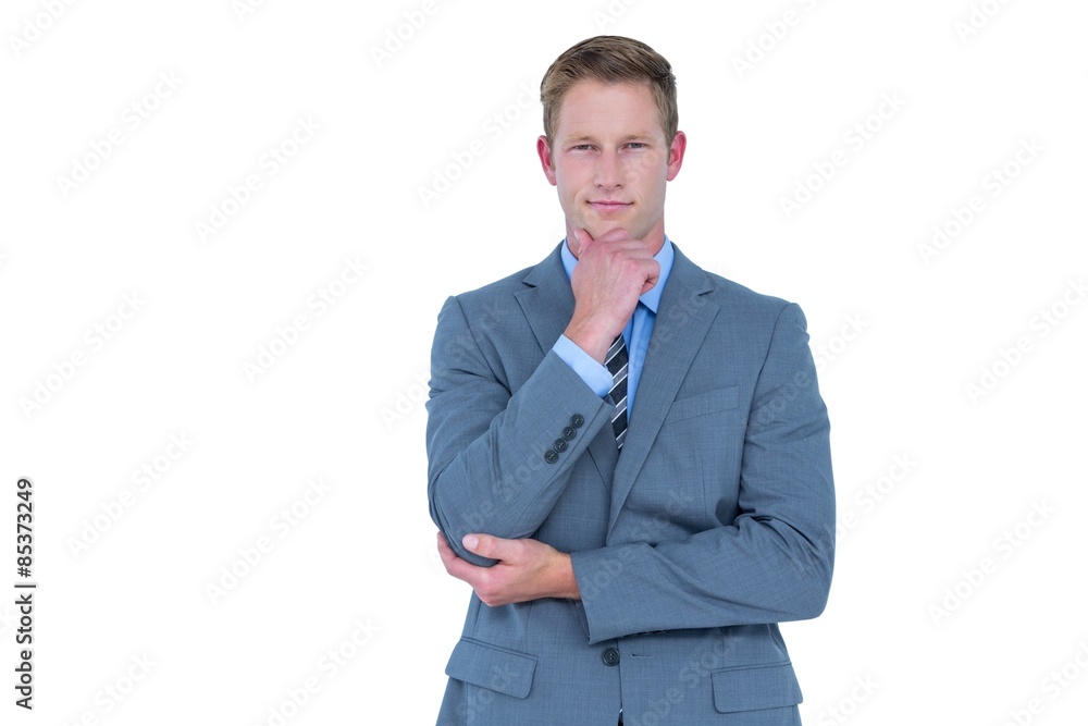 Businessman looking at camera with hand on chin Businessman looking at camera with hand on chin