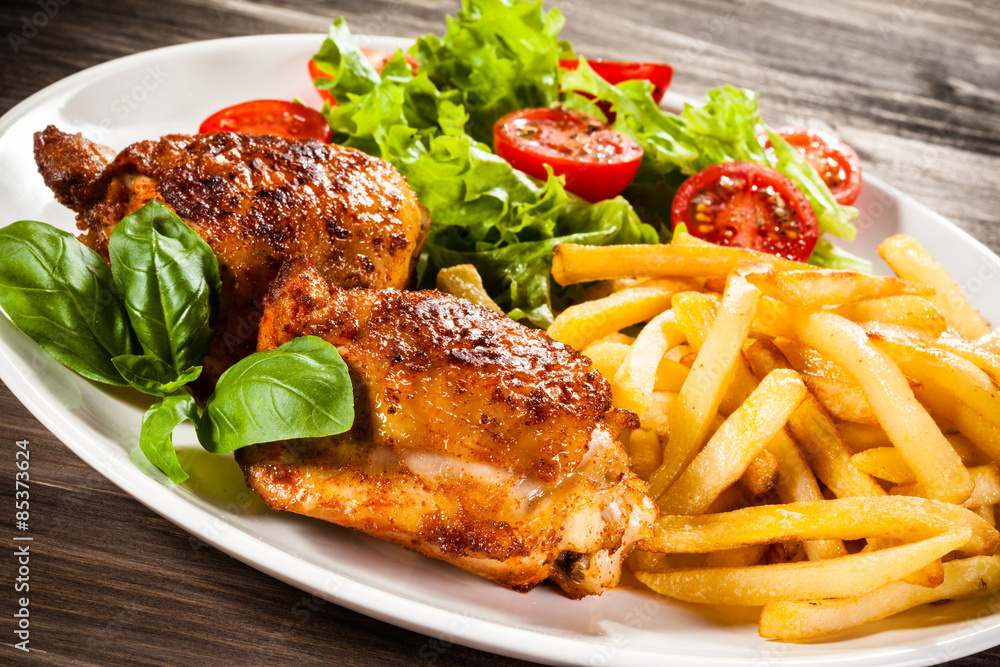 Grilled chicken legs with chips and vegetables Grilled chicken legs with chips and vegetables