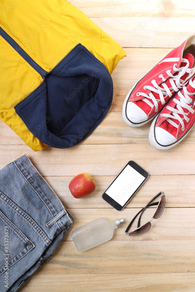 Outfit of traveler, student, teenager, young woman or guy. Overhead of essentials for modern young person. Different objects on wooden background. Outfit of traveler, student, teenager, young woman or guy. Overhead of essentials for modern young person. Different objects on wooden background.