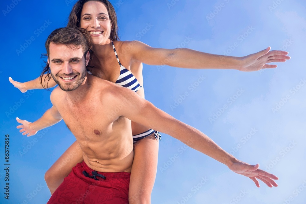 Man giving piggy back to his girlfriend at the beach Man giving piggy back to his girlfriend at the beach