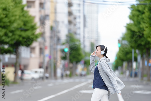 音楽を聞きながら街を歩く女性 © stockfoto