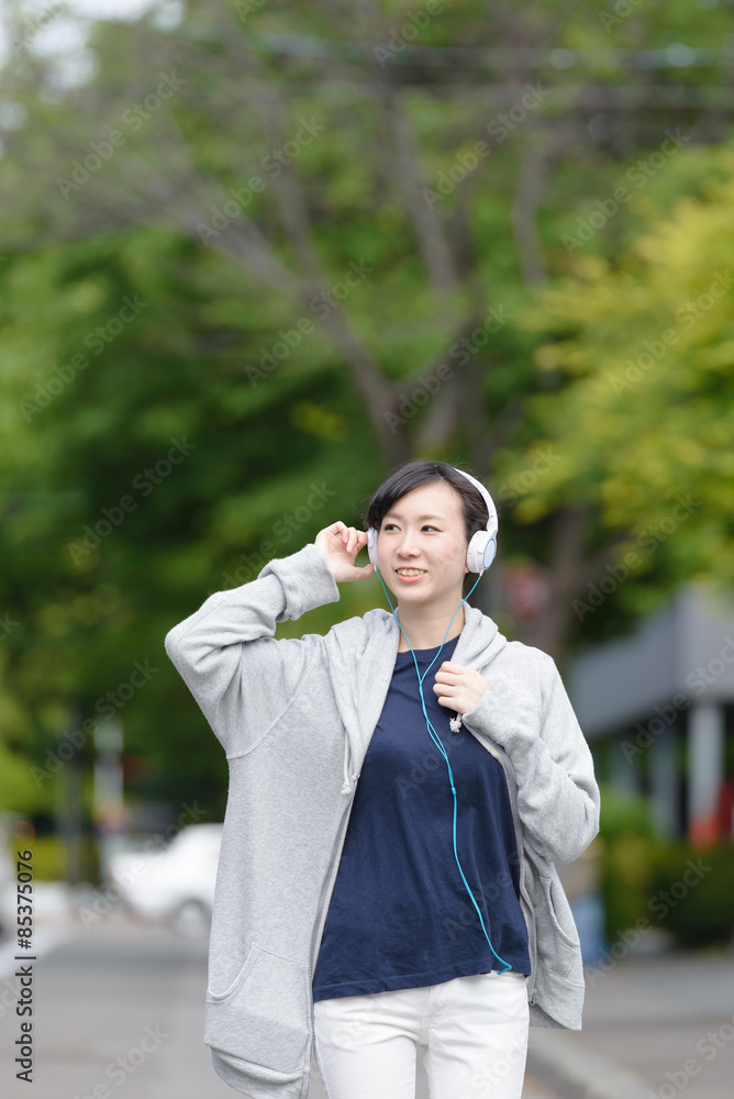 音楽を聞きながら歩く女性