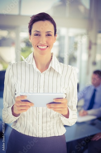 Businesswoman holding tablet and looking at camera 
