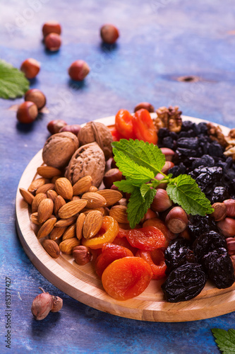 Fototapeta Naklejka Na Ścianę i Meble -  Healthy concept: assortment of dry fruits and nuts on blue rustic background. Selective focus