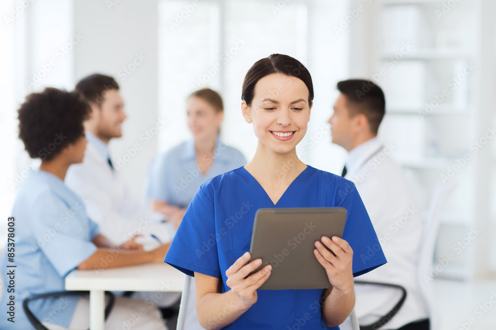 happy doctor with tablet pc over team at clinic happy doctor with tablet pc over team at clinic