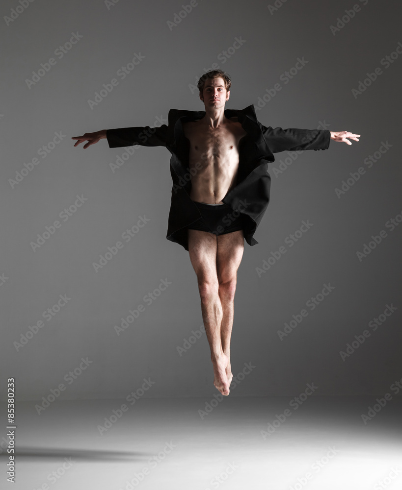 The young attractive modern ballet dancer jumping on white The young attractive modern ballet dancer jumping on white