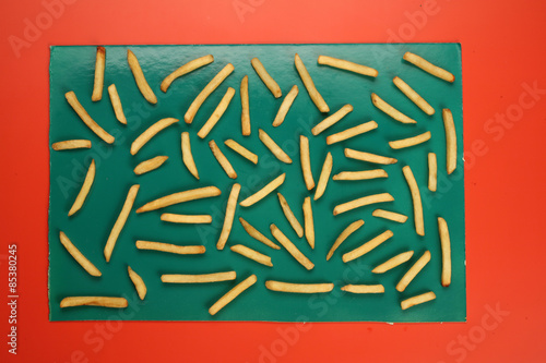 Obraz na plátně potato fried stics on green and red background