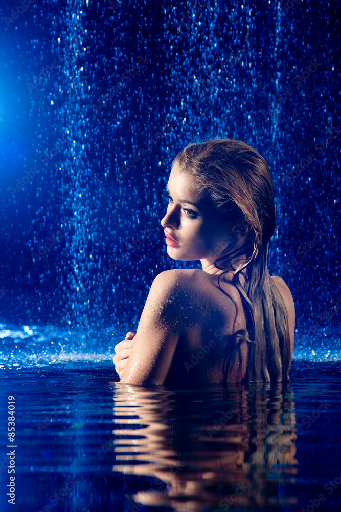 Beautiful long hair female model posing on swimming pool