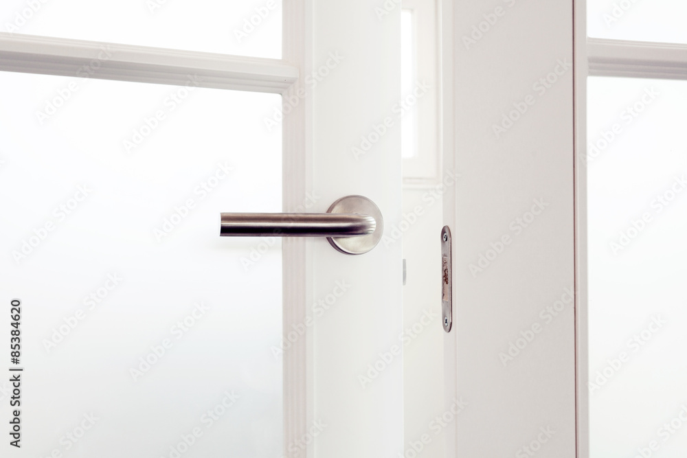 Open white door with metallic handle Open white door with metallic handle
