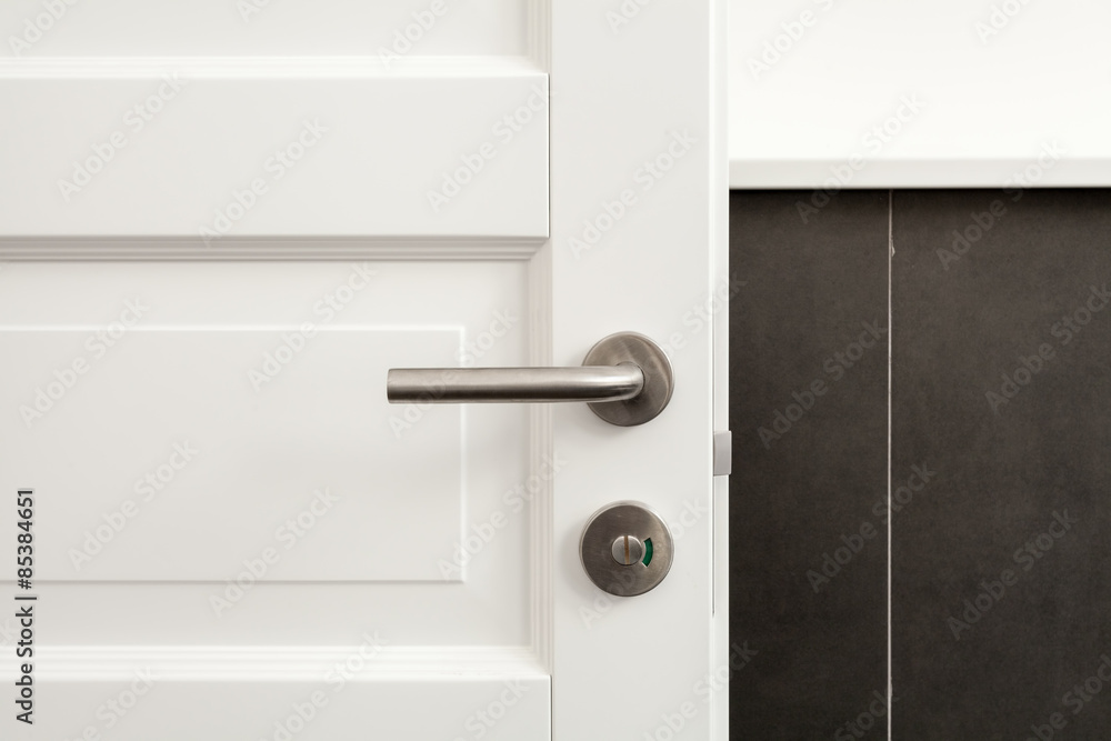 Open white door with metallic handle Open white door with metallic handle