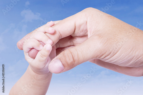 Infant hand gripping father finger © Creativa Images