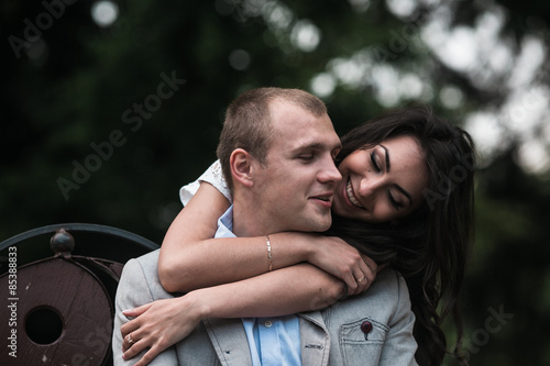 Young European couple cuddling on a park bench