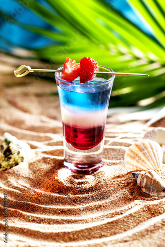 short cocktail on the sand white blue red strawberries